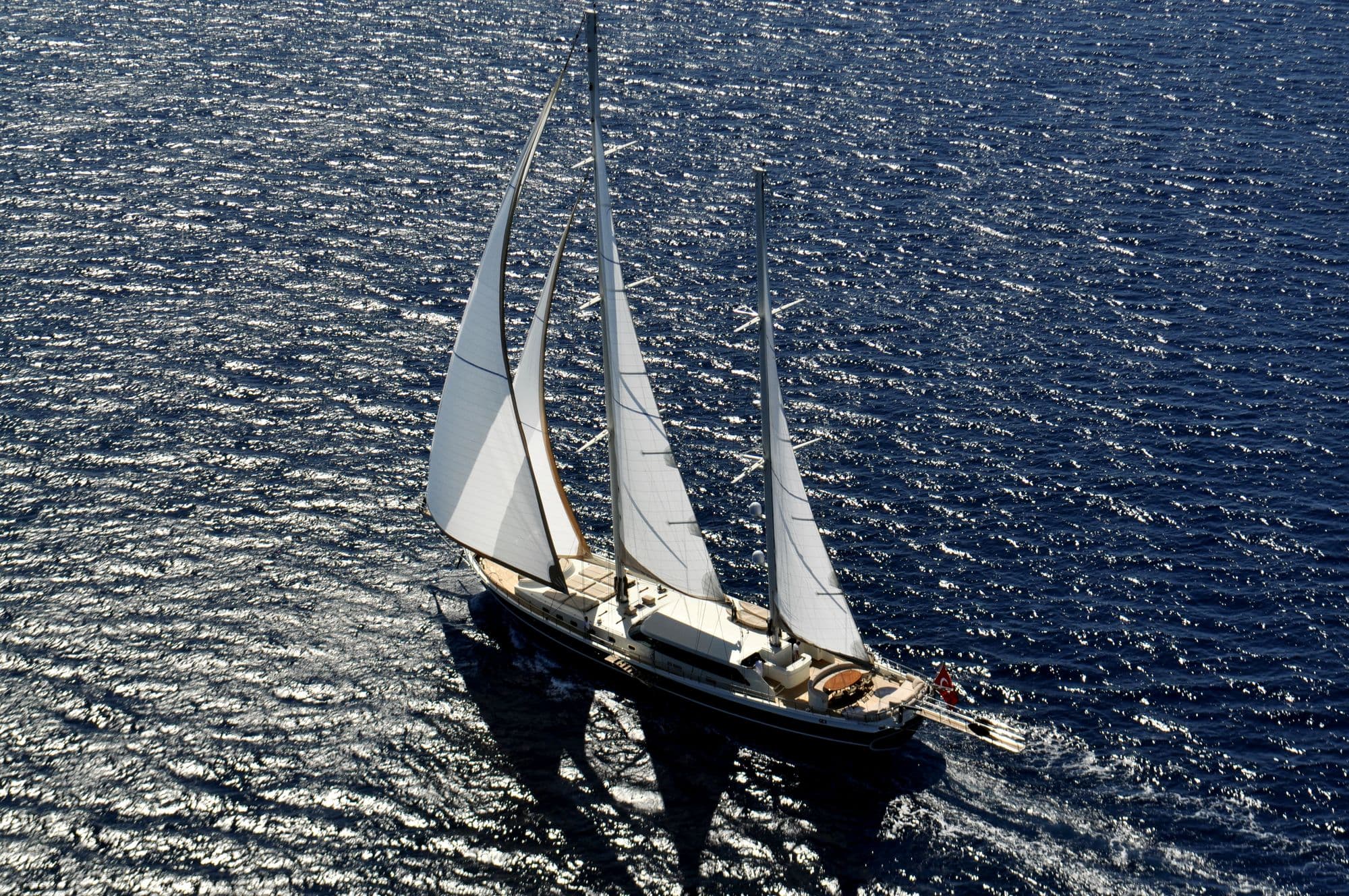 Dolce Mare sailing on a sparkling sea, from the air
