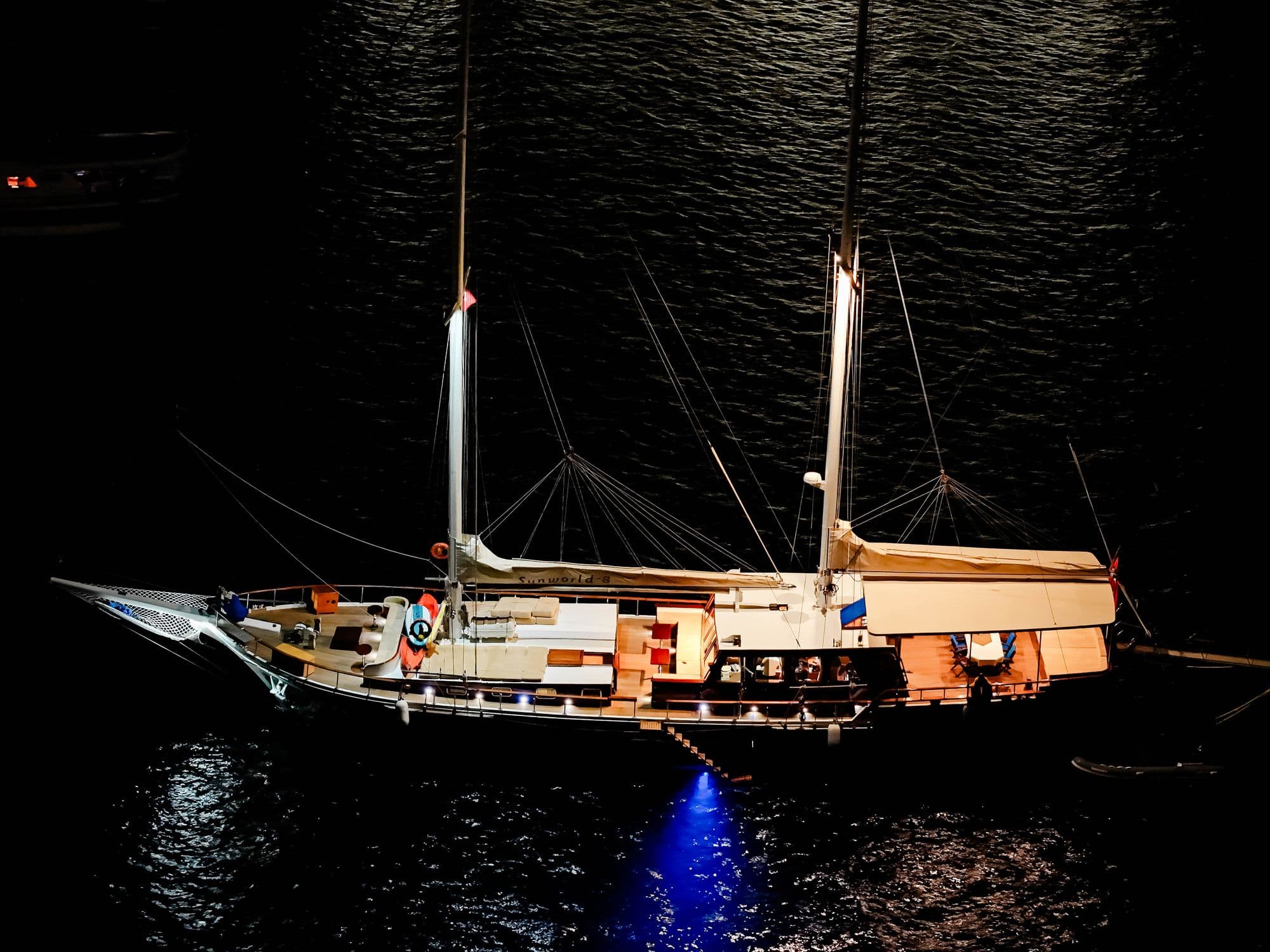 Sunworld-8 at anchor with her lights on at night, from the air